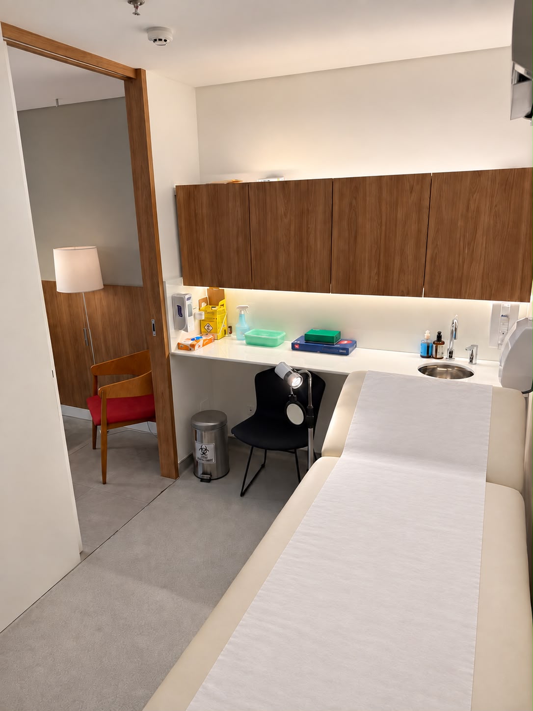 Mesa de atendimento e estante do consultório, com iluminação indireta